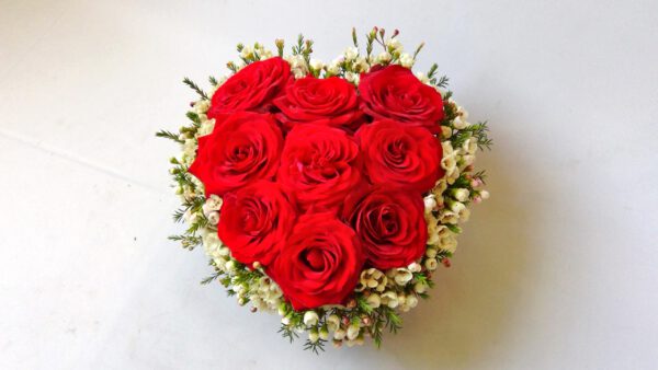 Flowerbox w kształcie serca wypełniony dużymi różami i chamelaucium